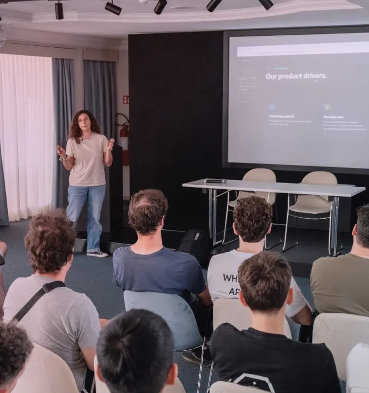 Una persona che presenta una slide davanti a un pubblico seduto