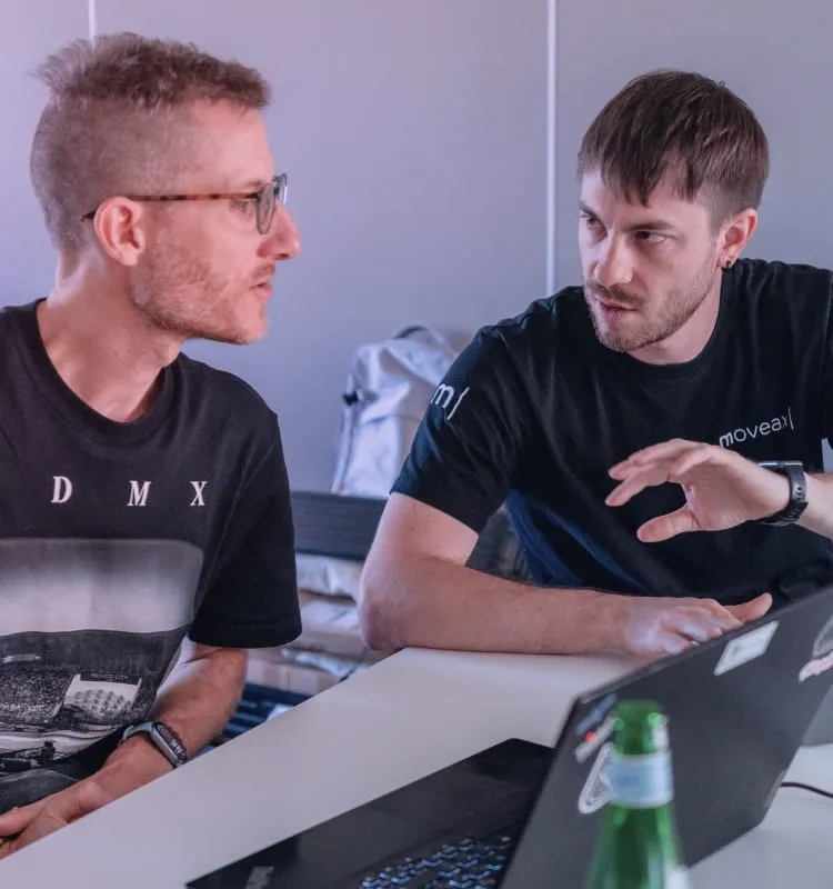 Due colleghi che parlano davanti ai loro laptop